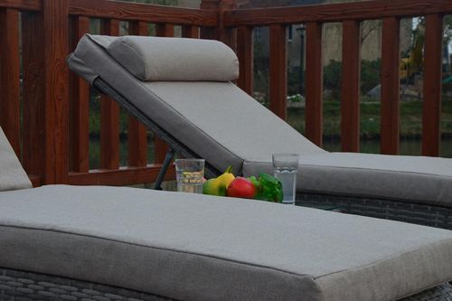 Rustic grey rattan sun loungers and table